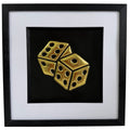 Framed gold leaf dice wall art with two raised dice on a black background, finished with a white mount and black frame.