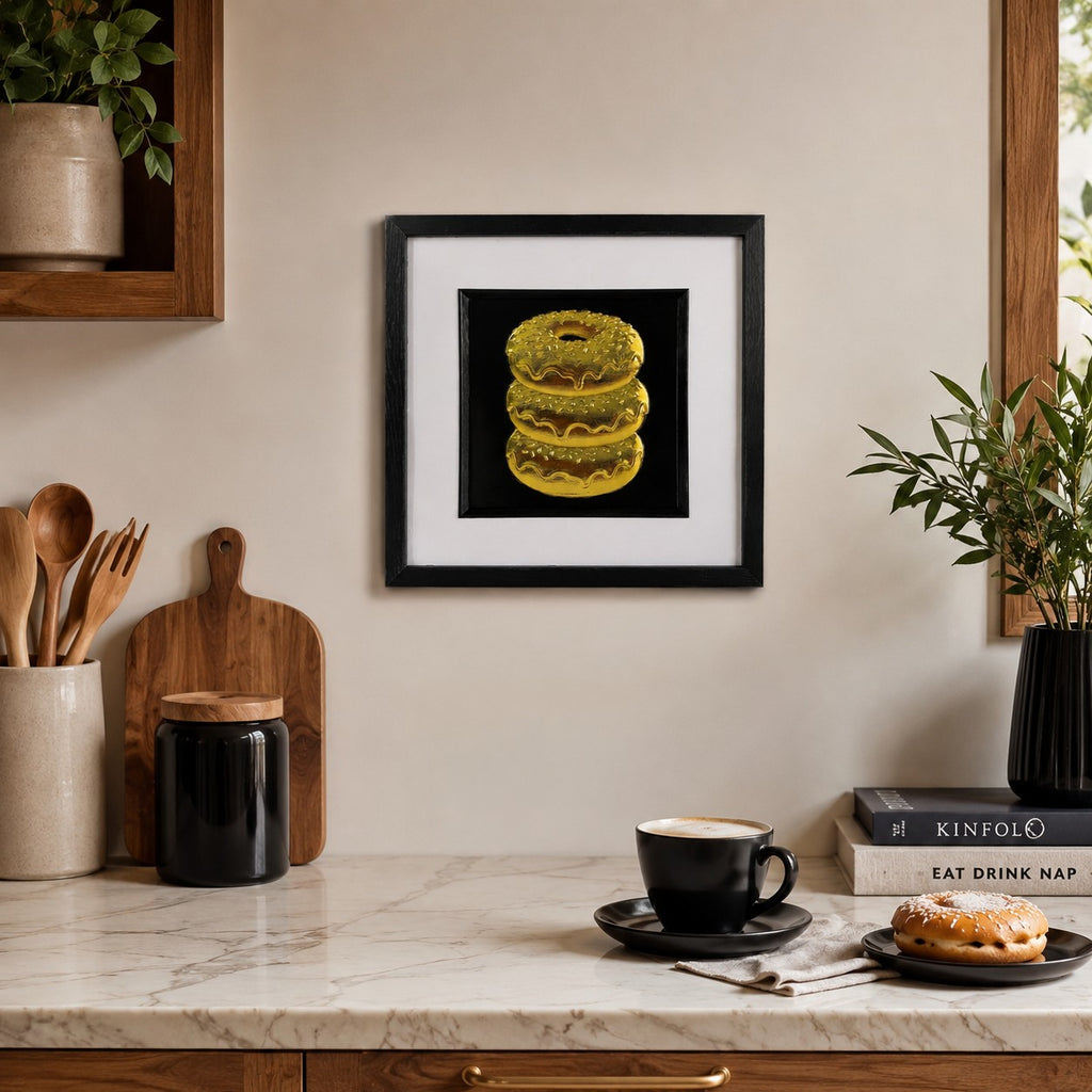 Gold doughnut stack framed artwork styled in a kitchen coffee area with shelves, plants and breakfast items.