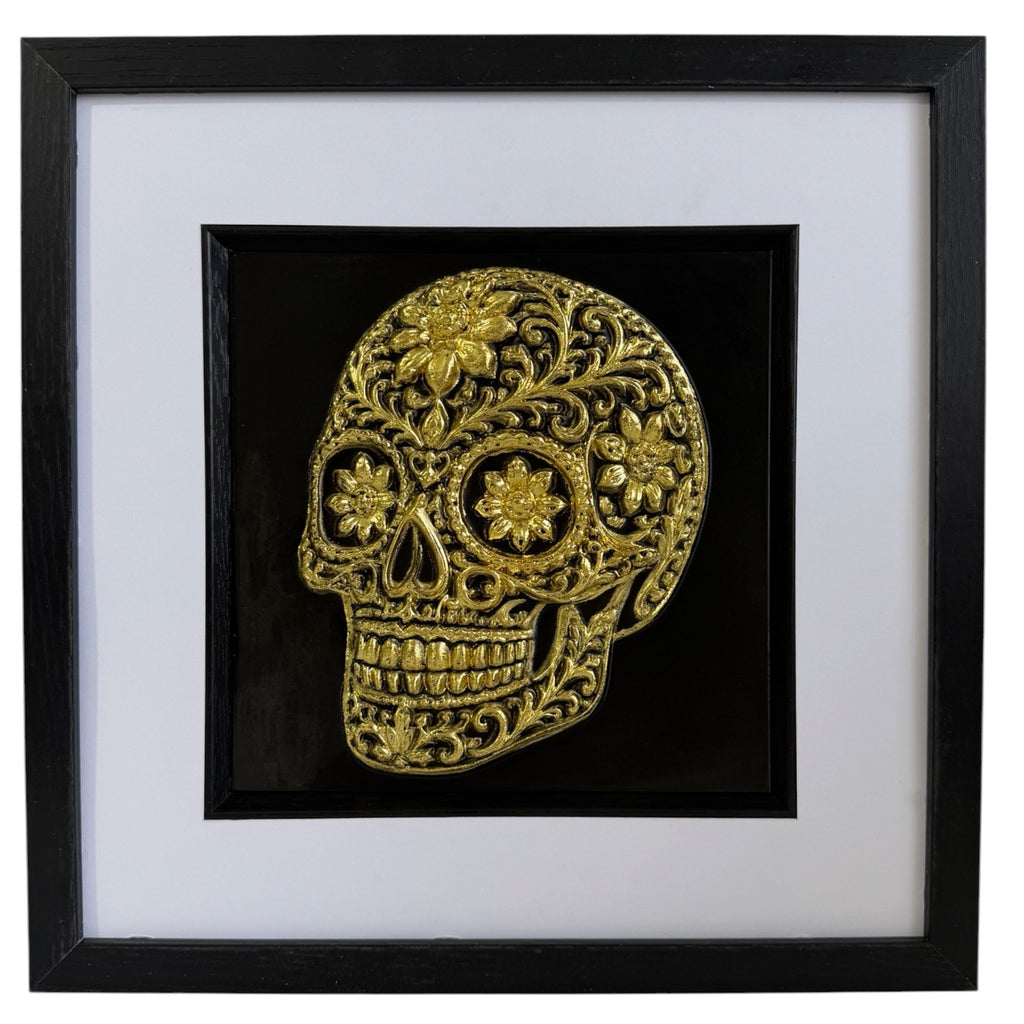 Gold floral sugar skull relief in a black frame with glass front, white mount and black inner surround