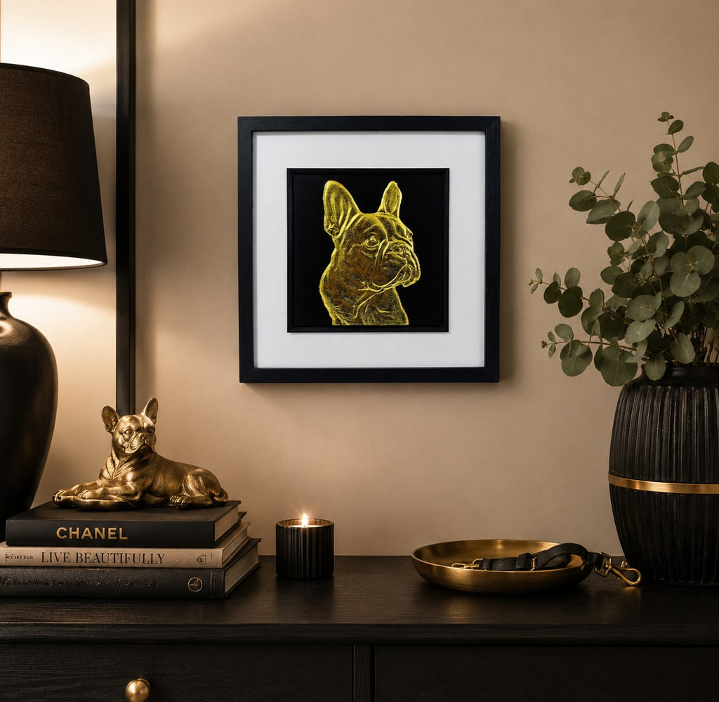 Framed gold French Bulldog wall art on a black background, styled in a warm modern home interior with black, gold and neutral decor accents.
