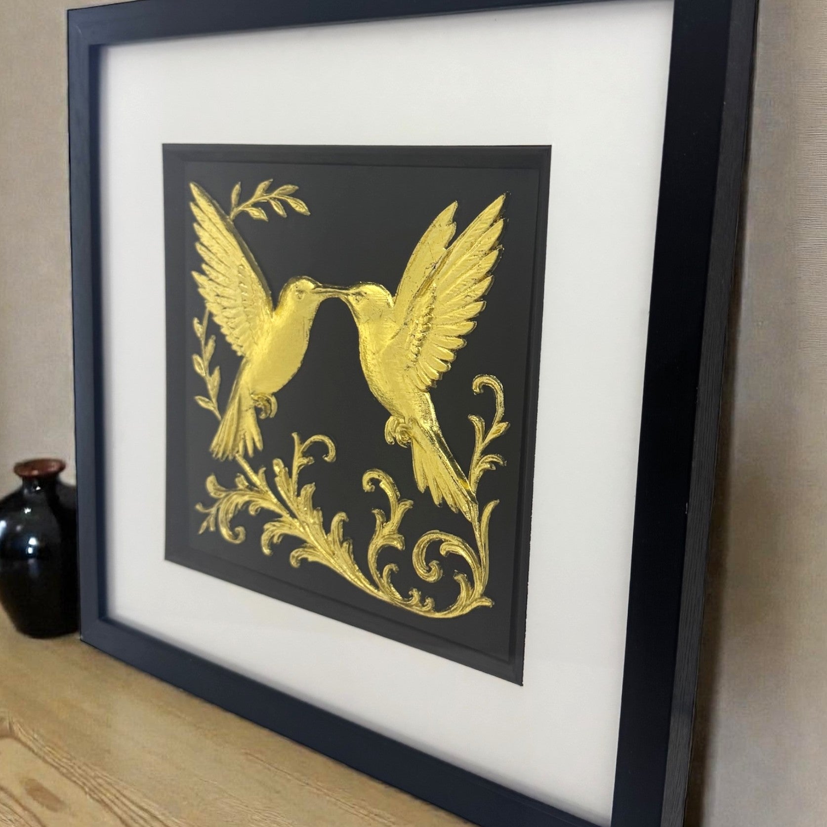 Gold hummingbird framed art styled on a wooden shelf. Unique hand-gilded anniversary or wedding gift idea with luxury finish.