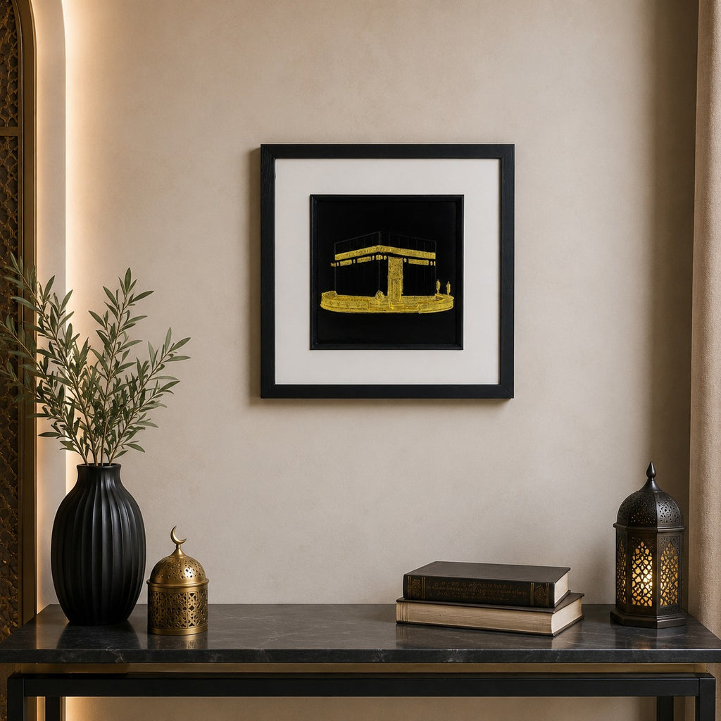 Gold Kaaba wall art displayed in a modern Islamic inspired interior, featuring a 33 cm square framed hand gilded gold leaf 3D relief design on a black background with elegant neutral decor.