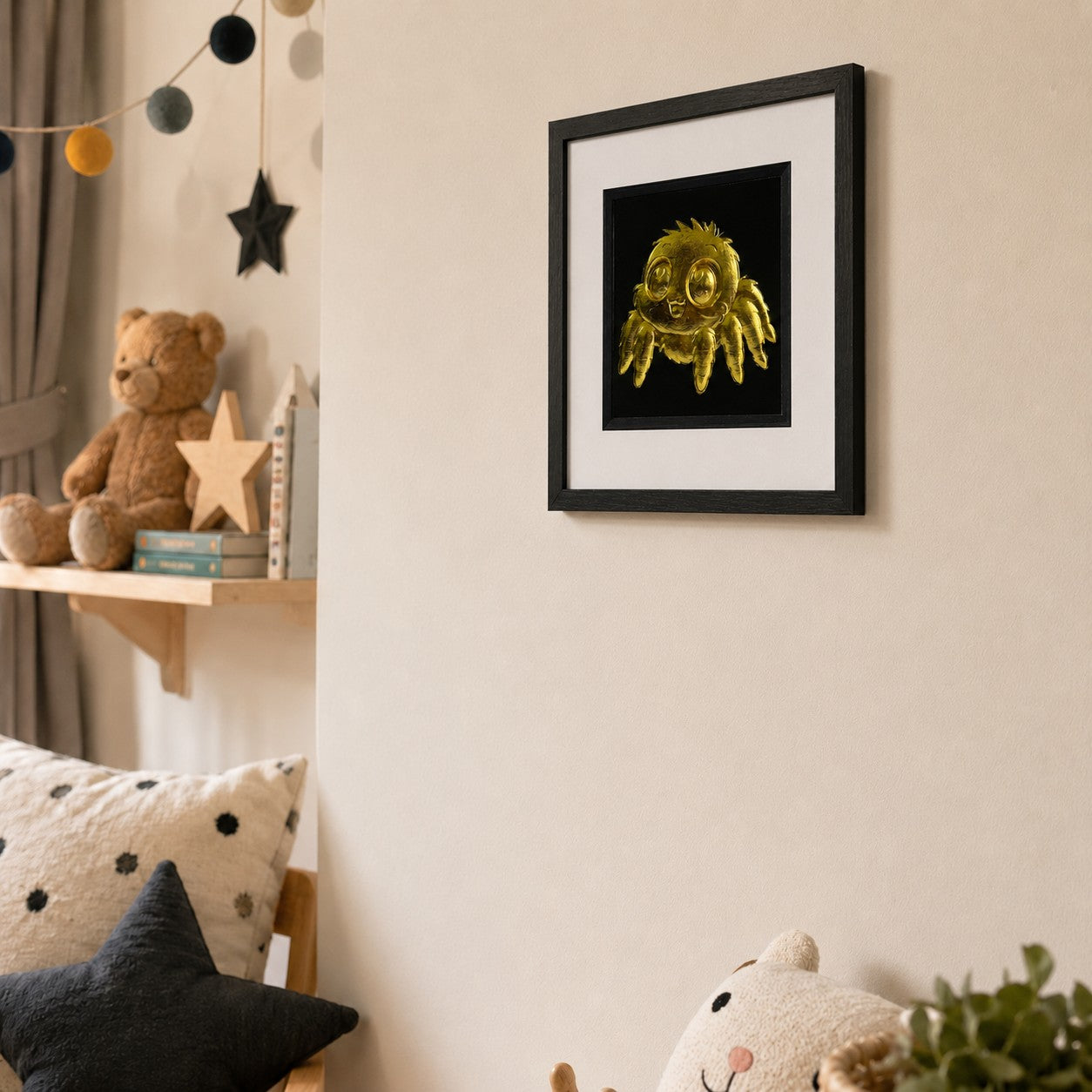 Angled view of framed gold kawaii spider wall art mounted on a soft neutral nursery wall, styled with teddy bear, books and playful children’s decor.