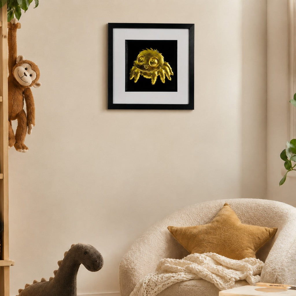 Framed gold kawaii spider wall art displayed in a warm nursery reading nook, styled with soft toys, books and neutral children’s room decor.