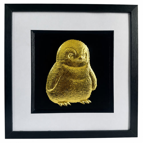 Framed gold leaf baby penguin wall art with a black background and white mount, ideal for nursery decor or cute animal wall art.