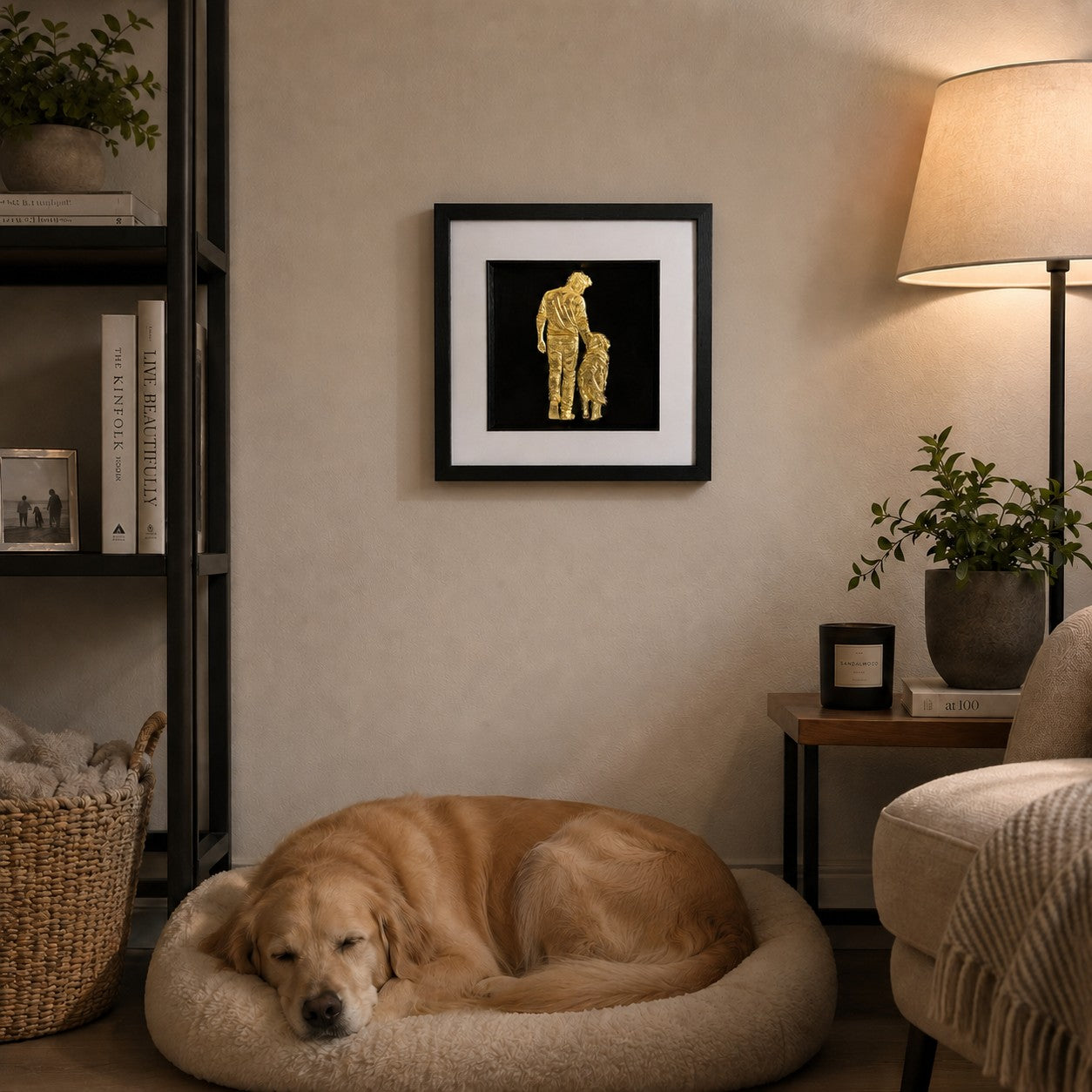 Gold finish man and dog artwork styled in a cosy living room above a sleeping dog with warm lamp light and plants.