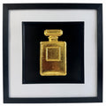 Gold leaf perfume bottle wall art in a black frame with white mount, featuring a hand gilded 3D relief design on a black background for elegant fashion inspired home decor.