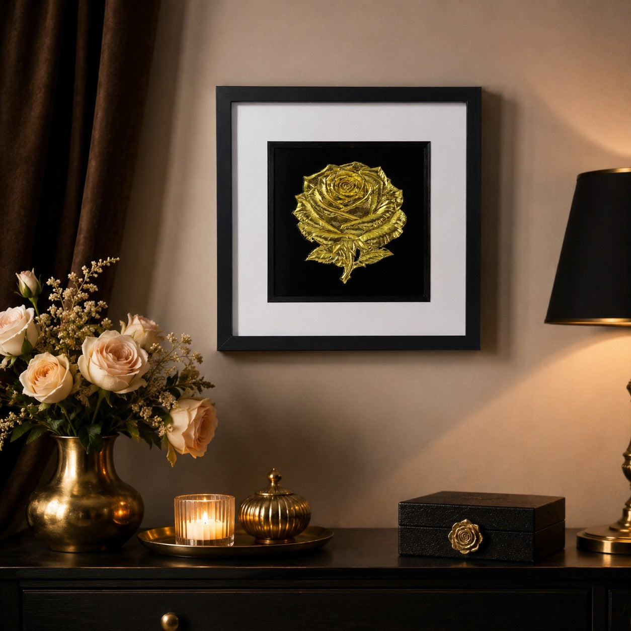 Gold rose wall art in a black square frame styled above a dark console with soft roses, candlelight, black and gold decor and warm romantic interiors.