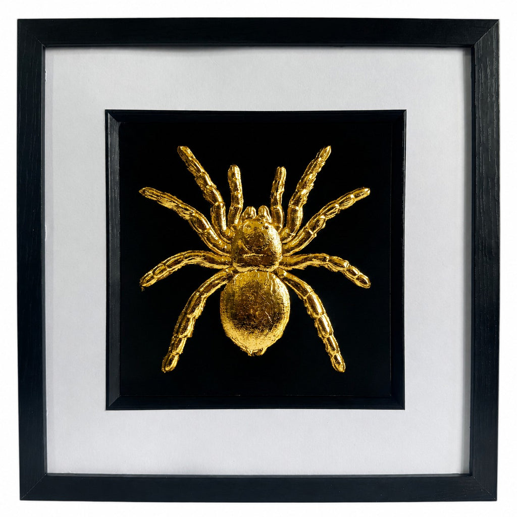 Framed tarantula spider wall art finished in realistic gold leaf, shown on a black background with a white mount and black frame for bold gothic wildlife decor.