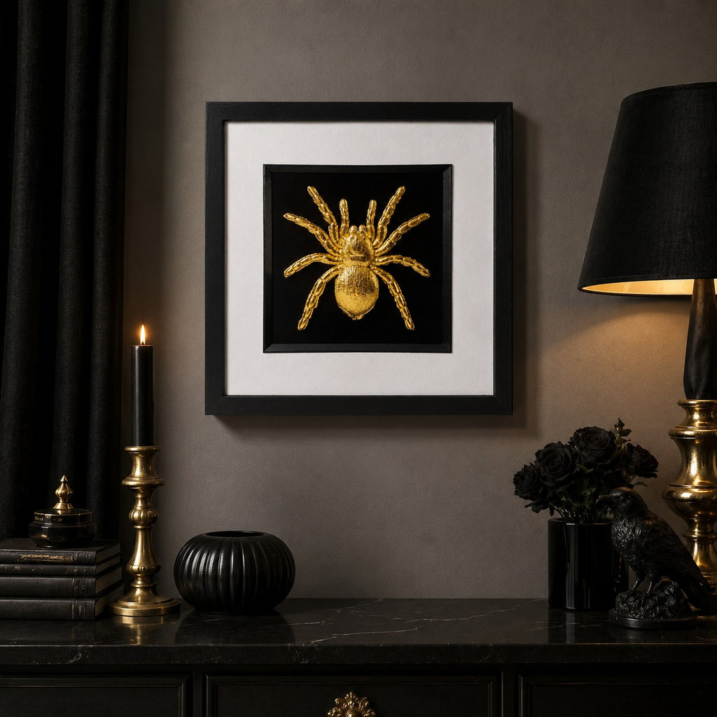 Gold tarantula spider framed wall art displayed in a moody gothic interior with black decor, candlelight, gold accents and a dark console table.