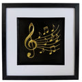Gold treble clef and musical notes relief shown straight-on in a black frame with wide white mount
