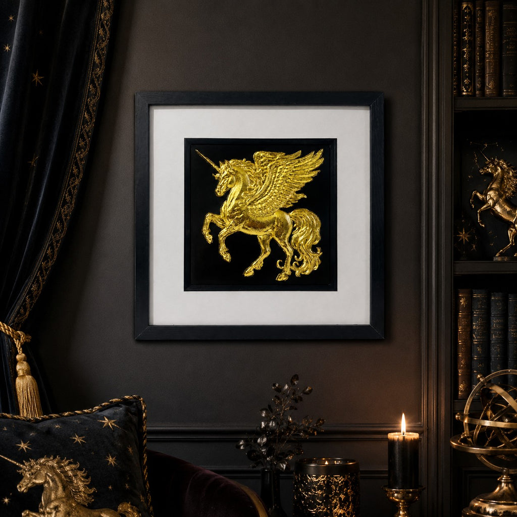 Gold winged unicorn framed wall art displayed on a dark wall in a luxury fantasy interior with black velvet, candlelight, gold accents and celestial decor.
