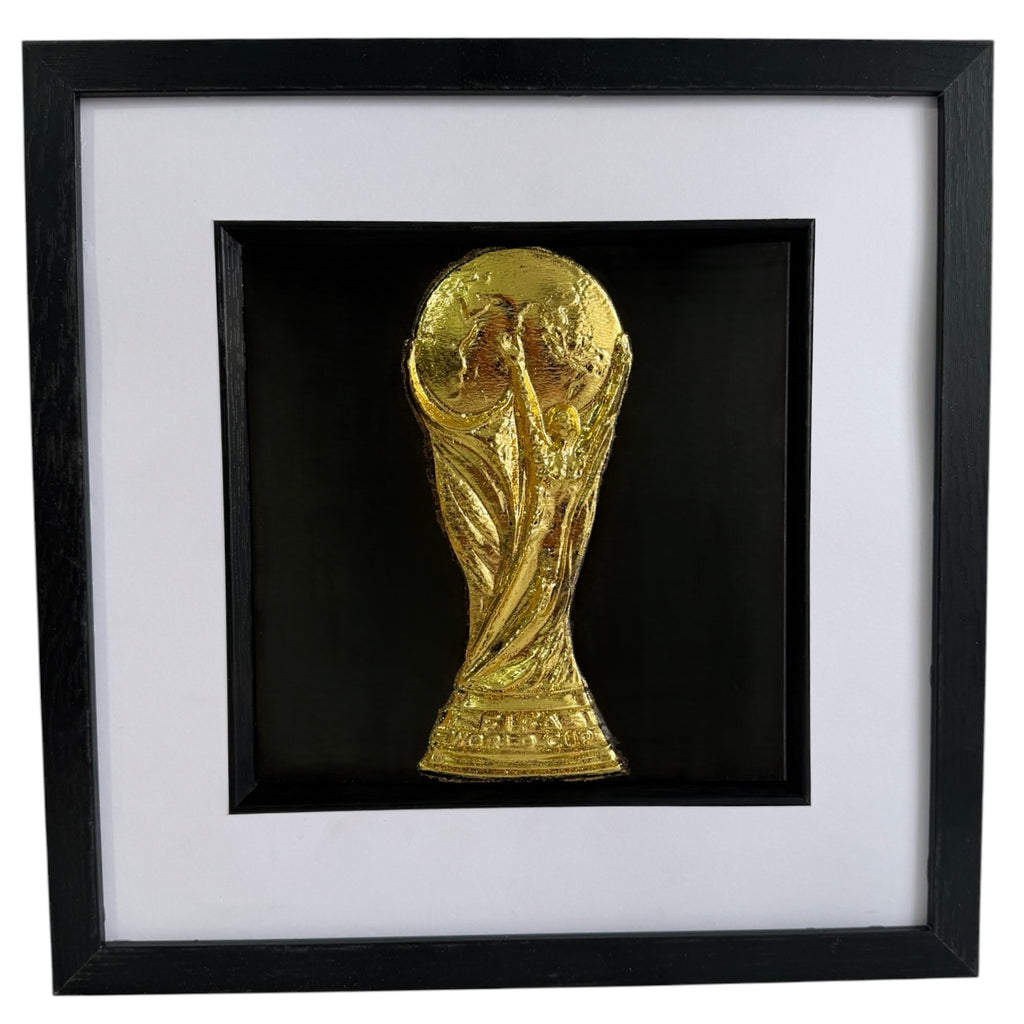 Gold World Cup trophy inspired 3D football wall art in a black box frame with white mount and black inner surround.