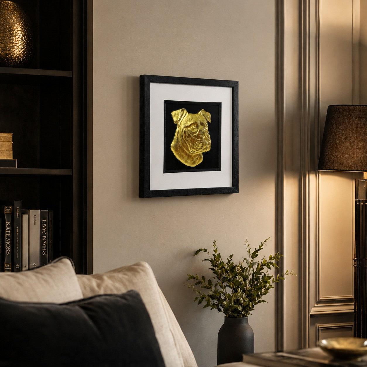 Angled view of framed gold XL Bully dog portrait 3D wall art on a warm modern living room wall with black frame, white mount and luxury interior styling.
