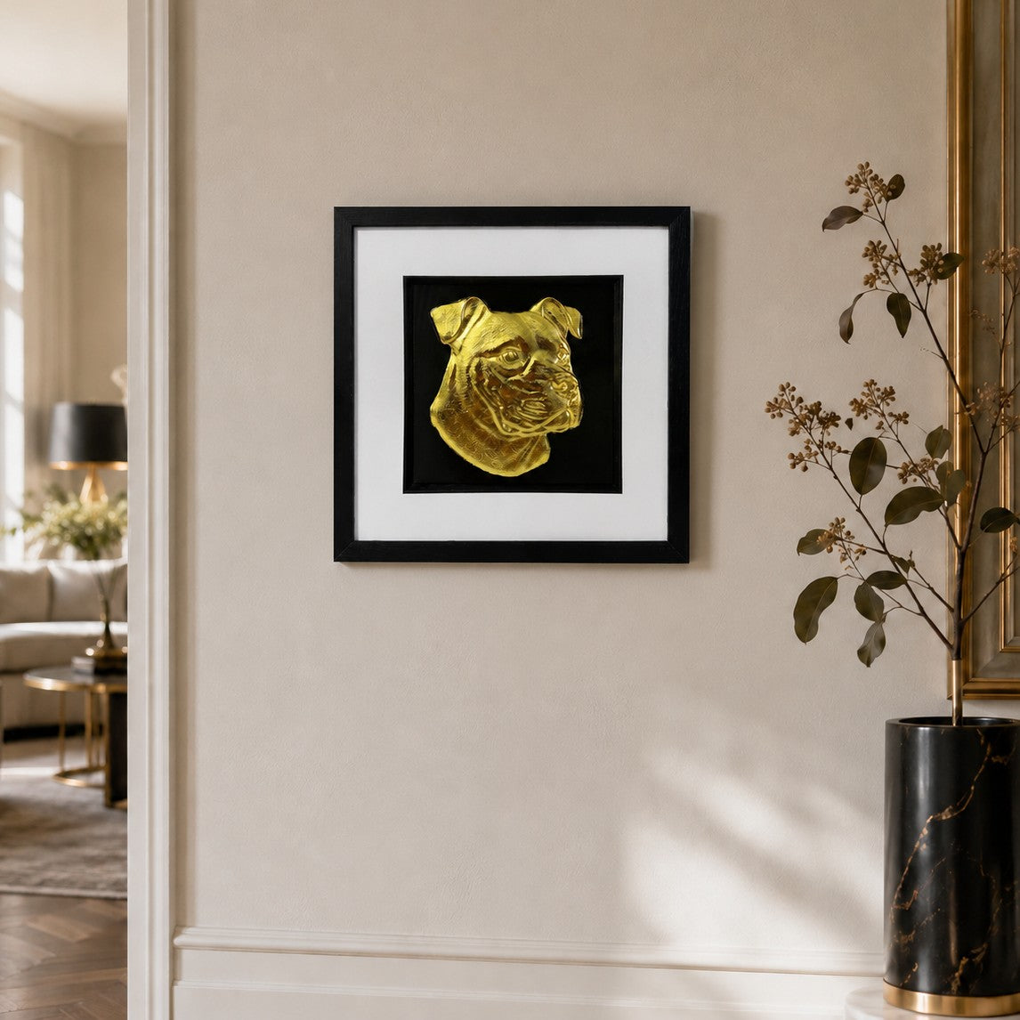 Framed gold XL Bully dog portrait 3D wall art on a modern neutral living room wall with black frame, white mount and gold decor accents.