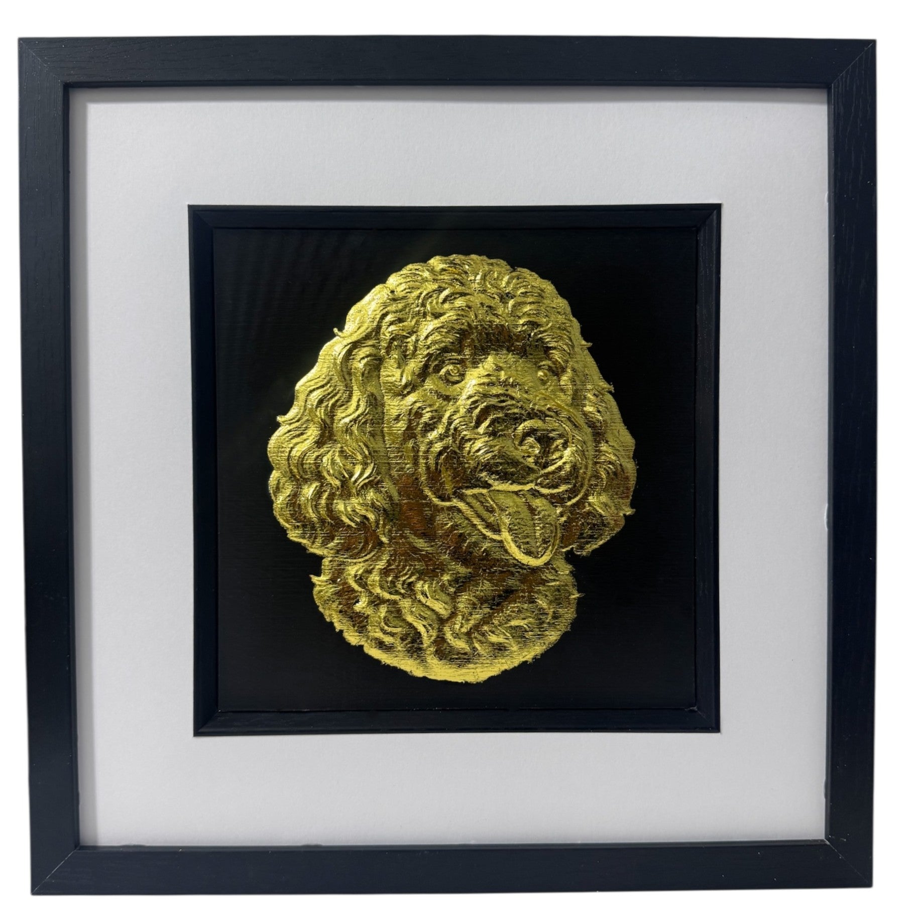Goldendoodle framed wall art showing a sculpted dog portrait with curly coat in gold leaf, set on a black background with white mount and black wooden frame
