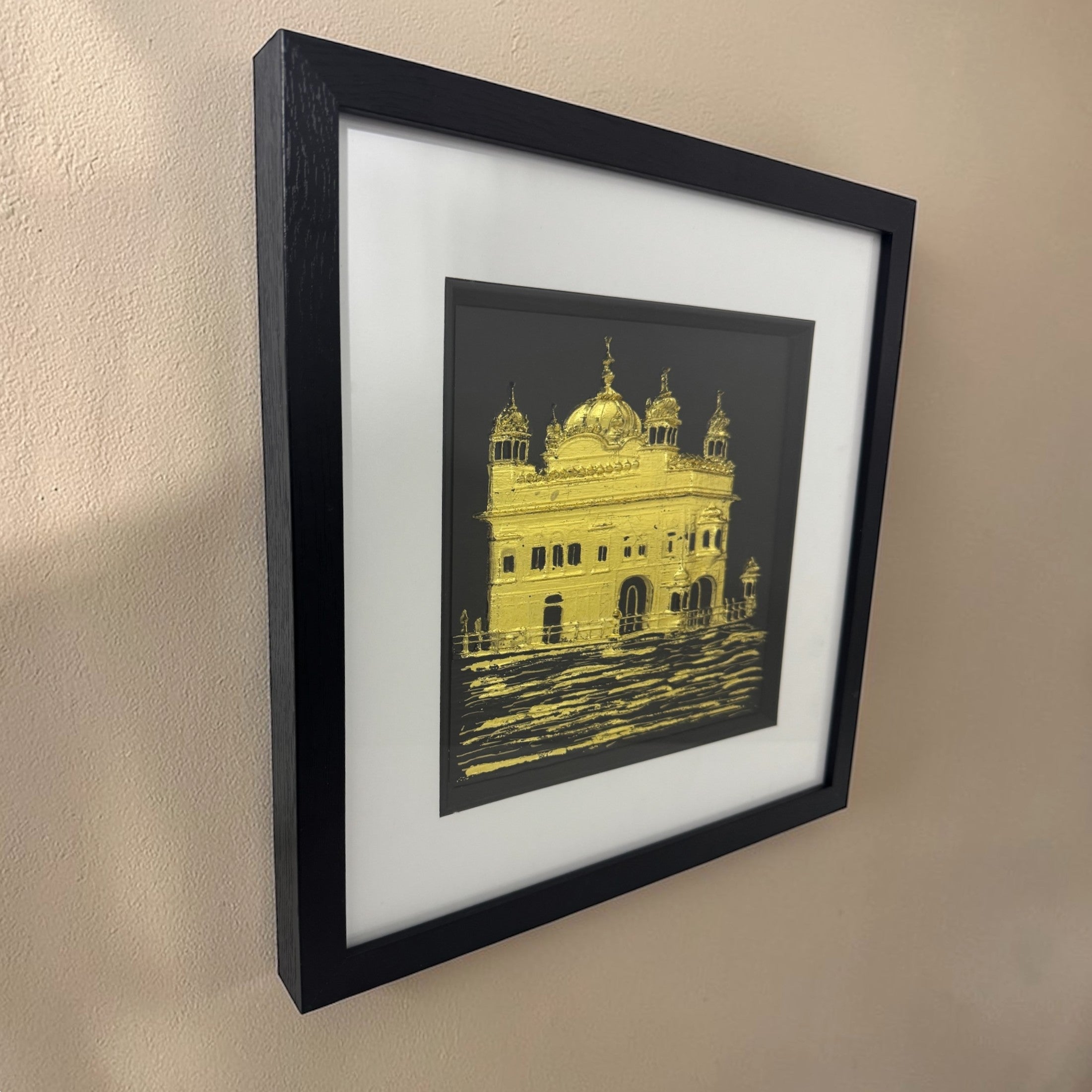 Framed Harmandir Sahib artwork with reflective water detail on wall