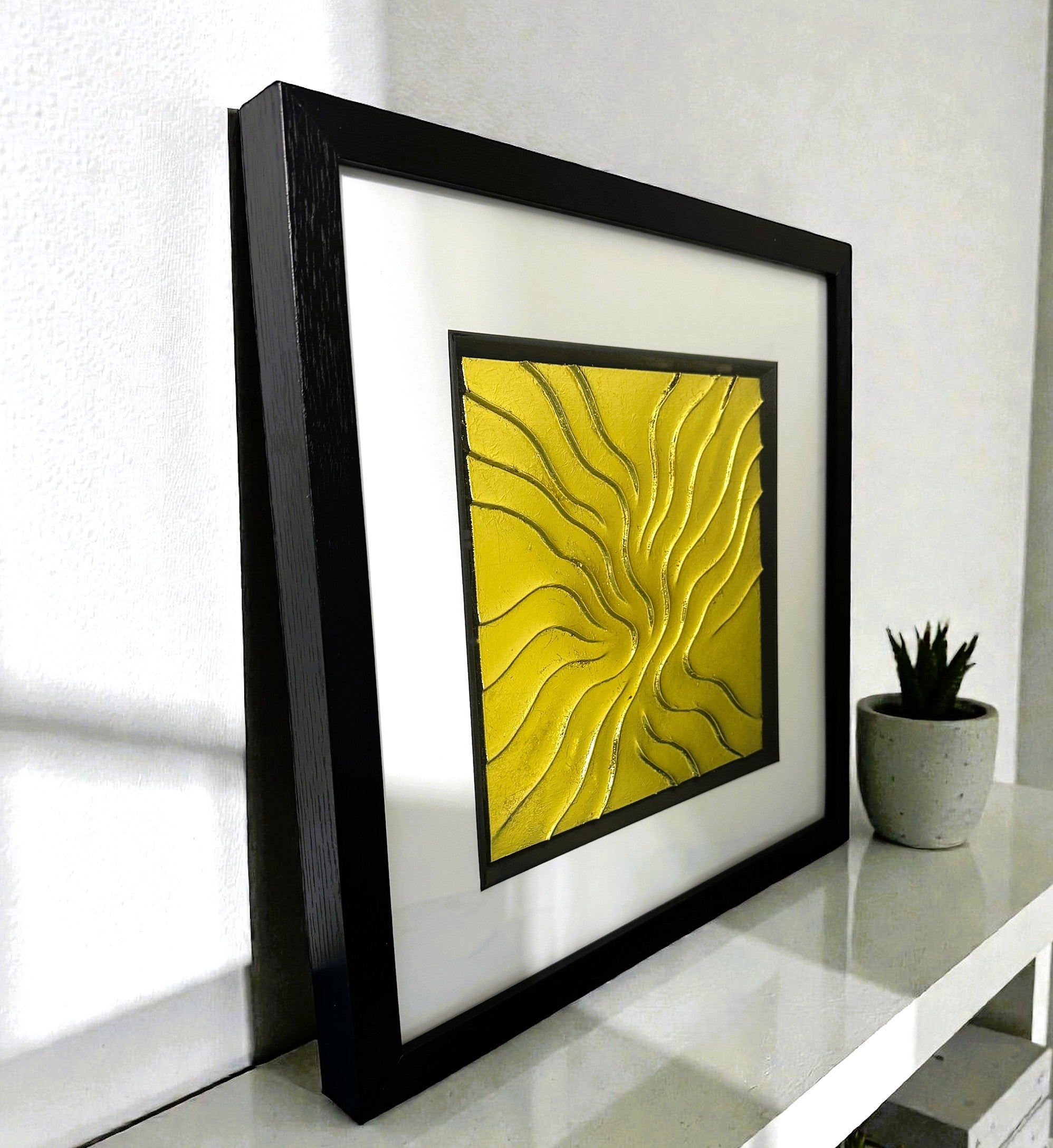 Angled view of Golden Flow wall art displayed on a shelf