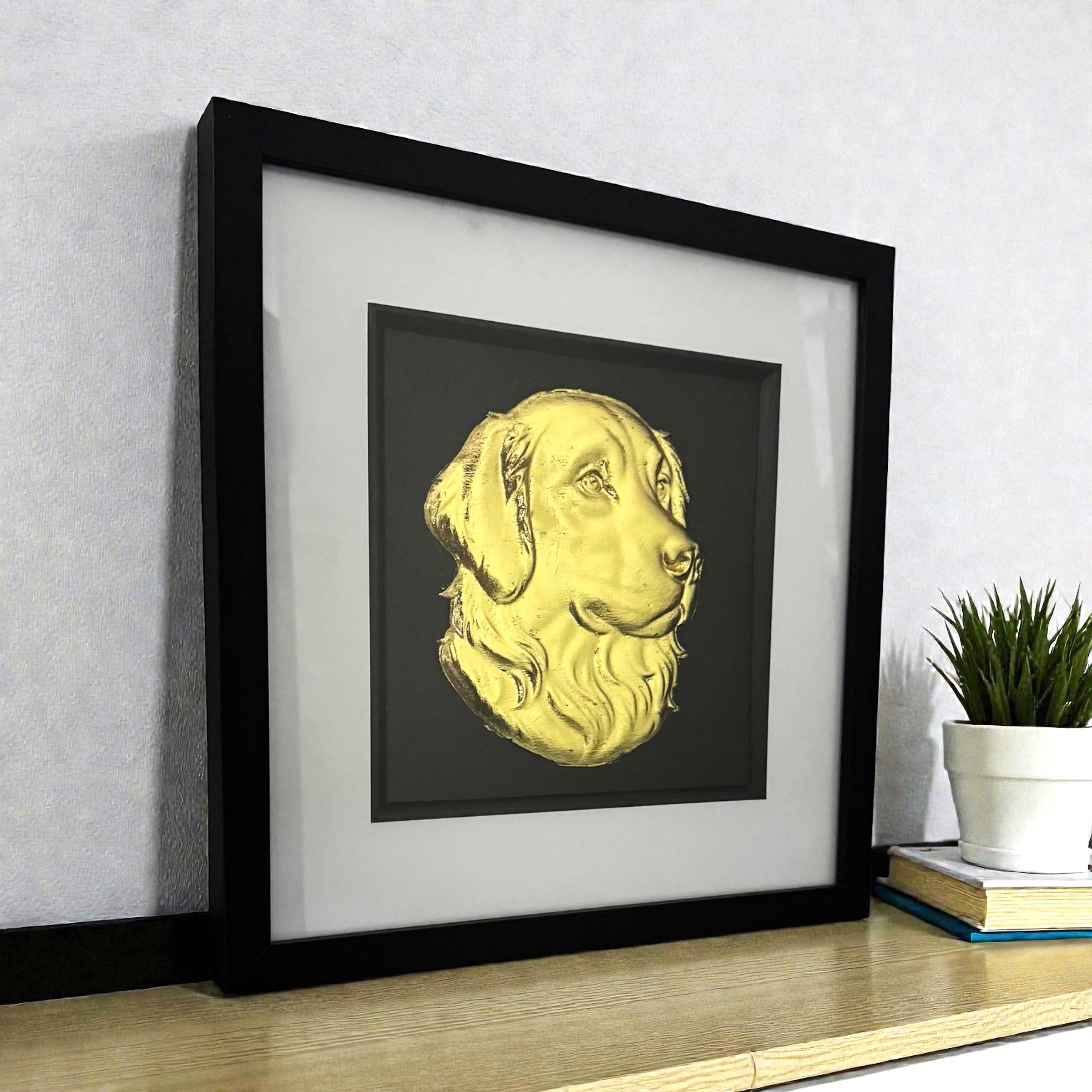 Golden Retriever framed wall art in gold leaf viewed at an angle, displayed in a black wooden frame with white mount

