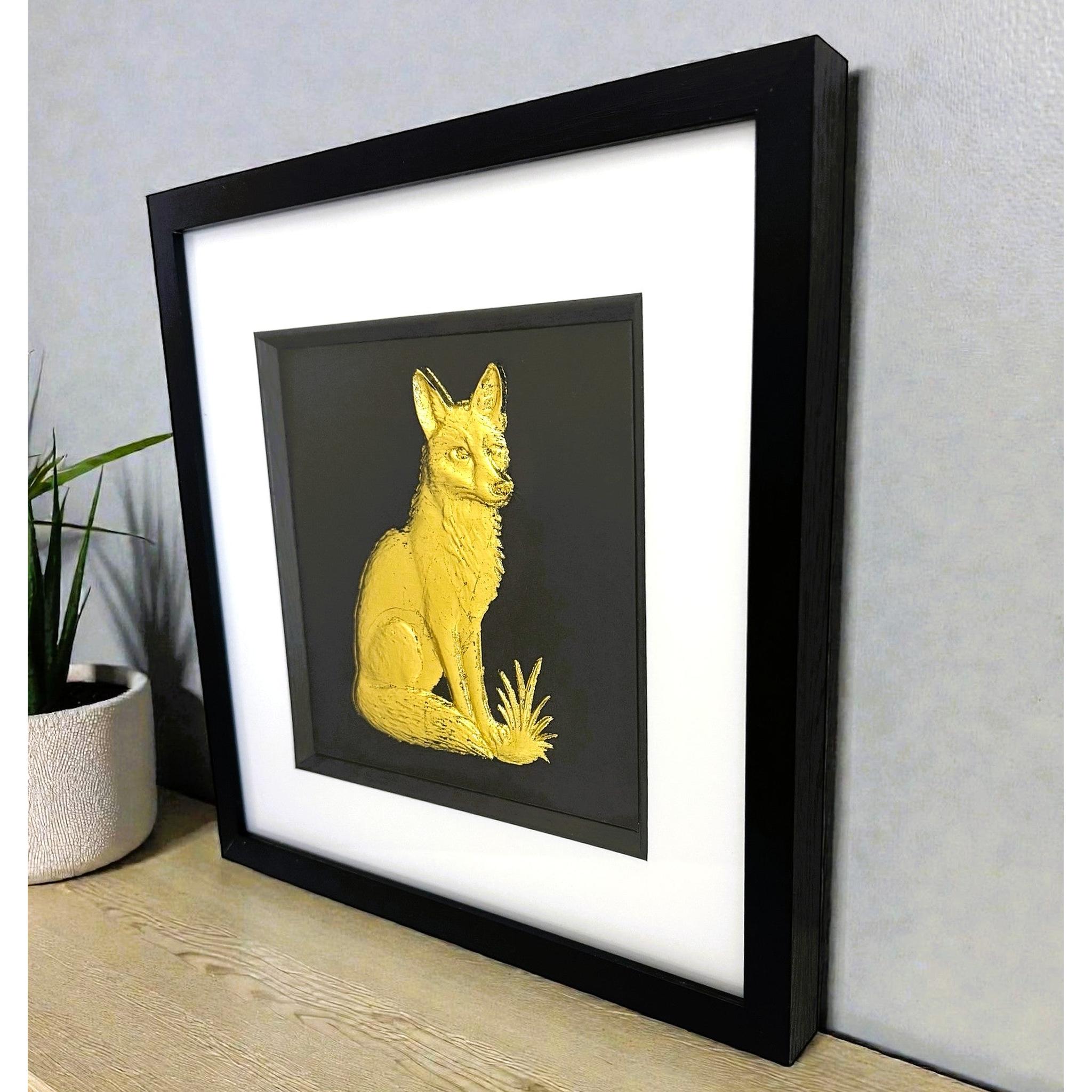 Angled view of gold leaf fox framed wall art displayed on shelf
