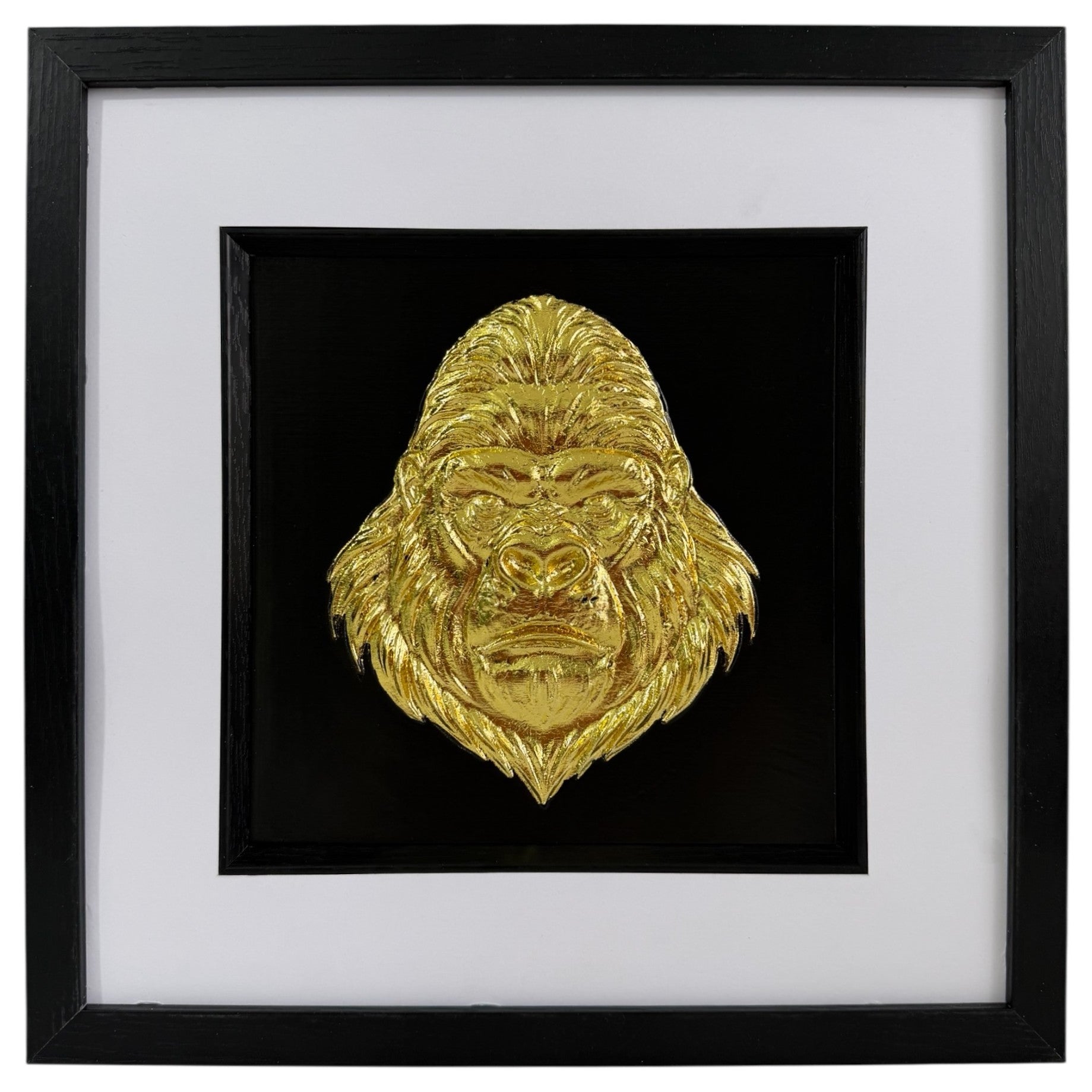 Gold framed gorilla head wall art with raised relief face, black backing, white mount and black frame.