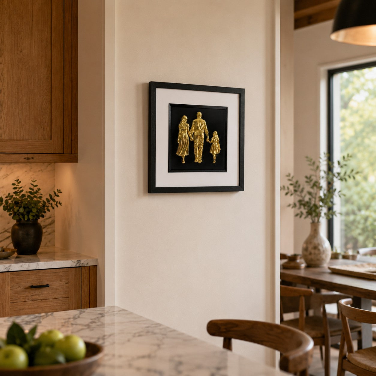 Framed Gold family artwork with white mount and black inner surround styled in warm kitchen and dining space.