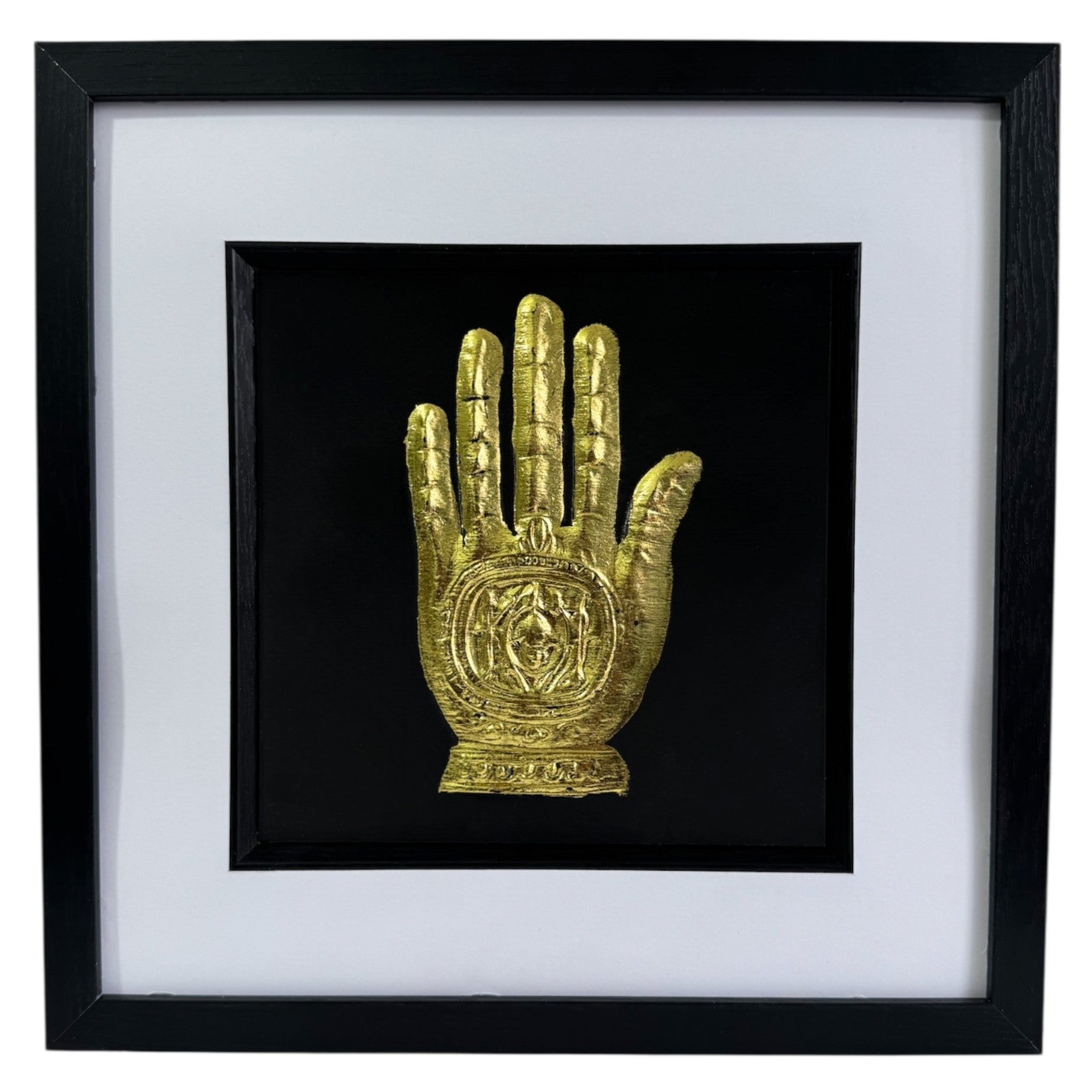 Front-facing gold leaf Hand of Fatima wall art centred on a black background with white mount