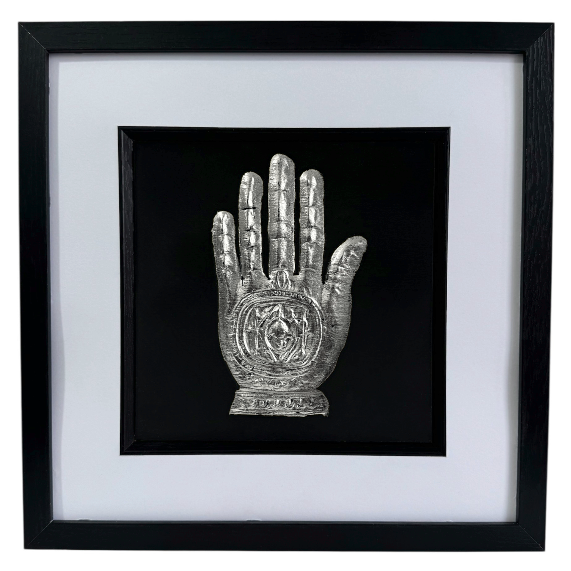 Silver leaf Hand of Fatima wall art shown from the front in a black wooden frame with white mount
