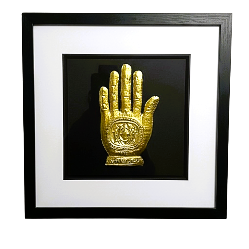 Front-facing gold leaf Hand of Fatima wall art centred on a black background with white mount
