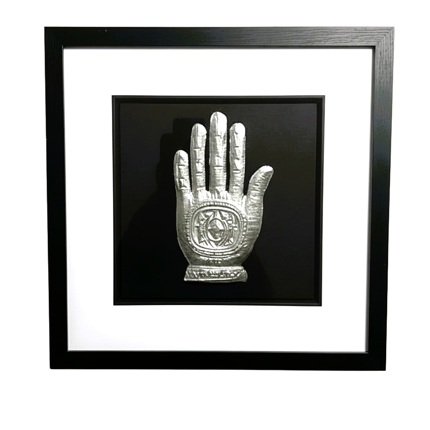 Silver leaf Hand of Fatima wall art shown from the front in a black wooden frame with white mount