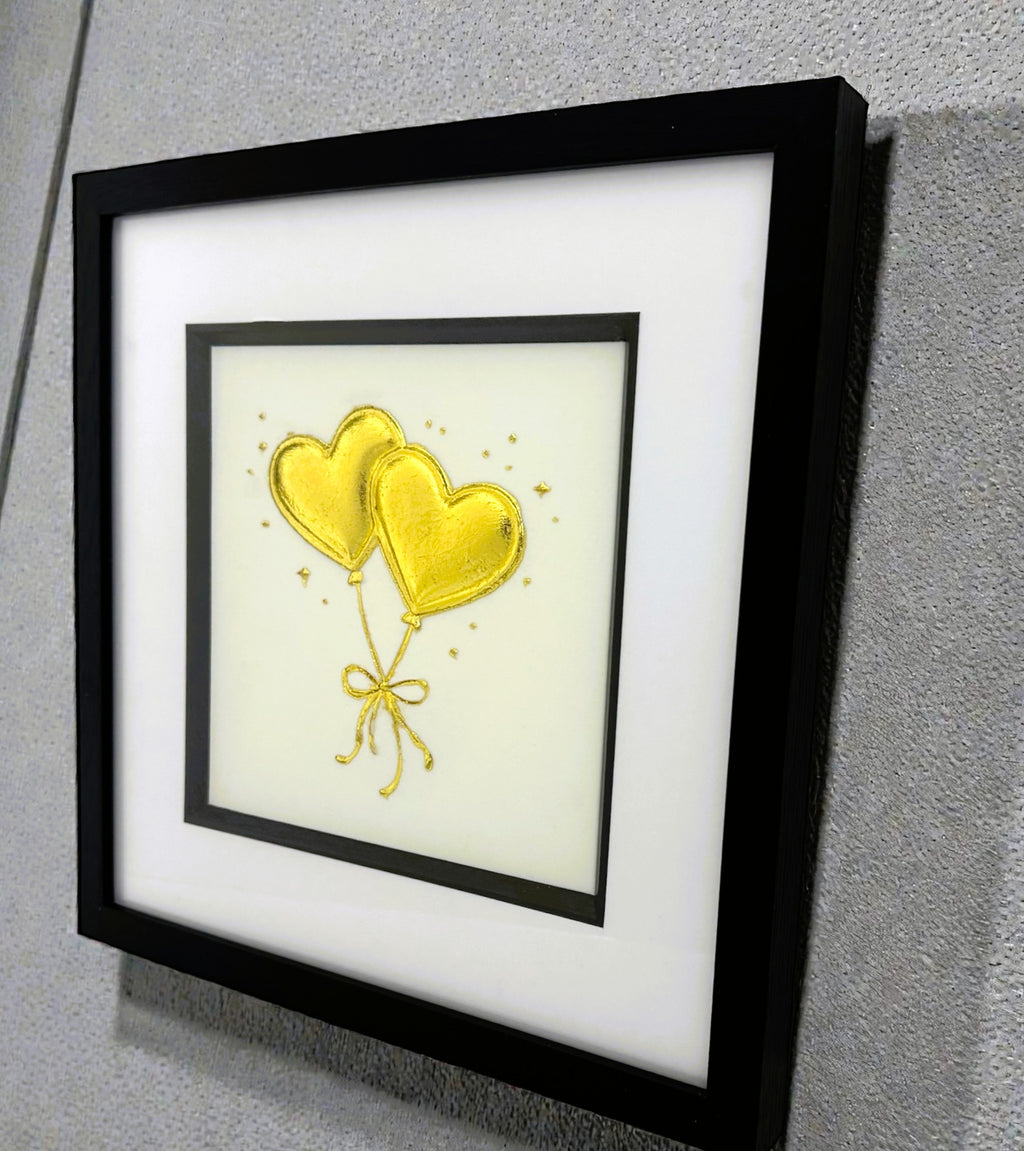 Angled wall-mounted heart balloons wall art framed in black with white mount