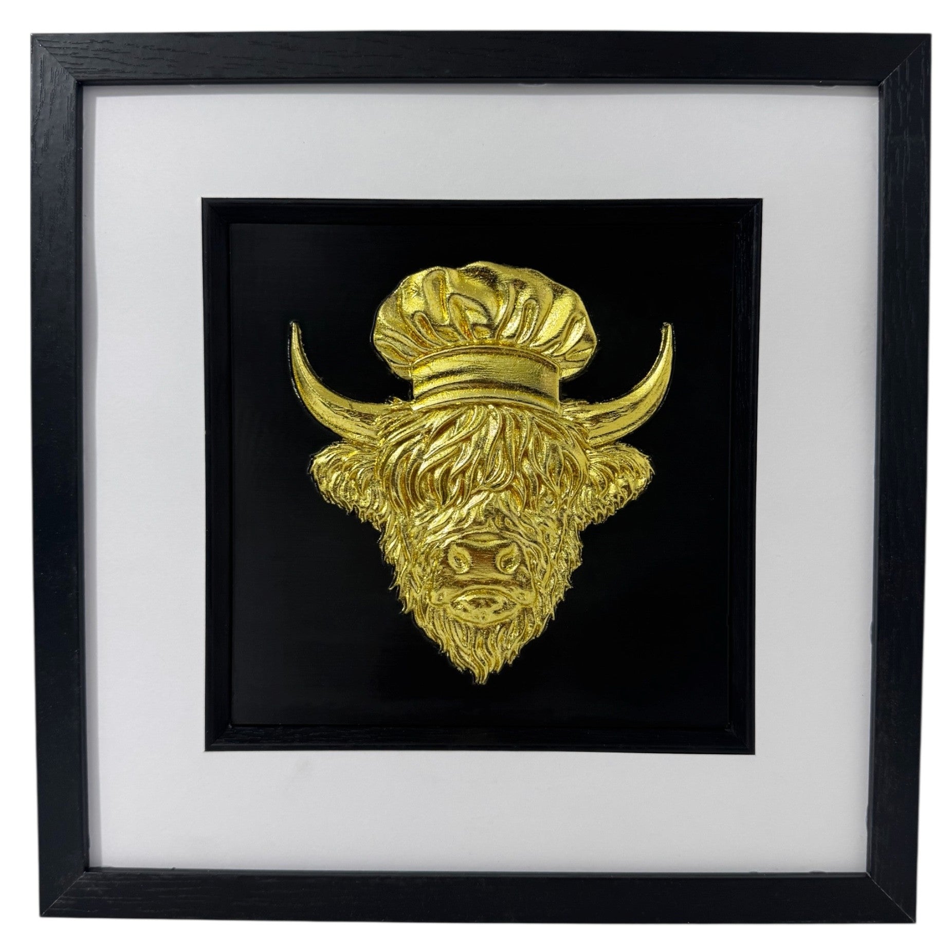 Gold Highland cow chef relief in a black box frame with wide white mount and black inner surround.