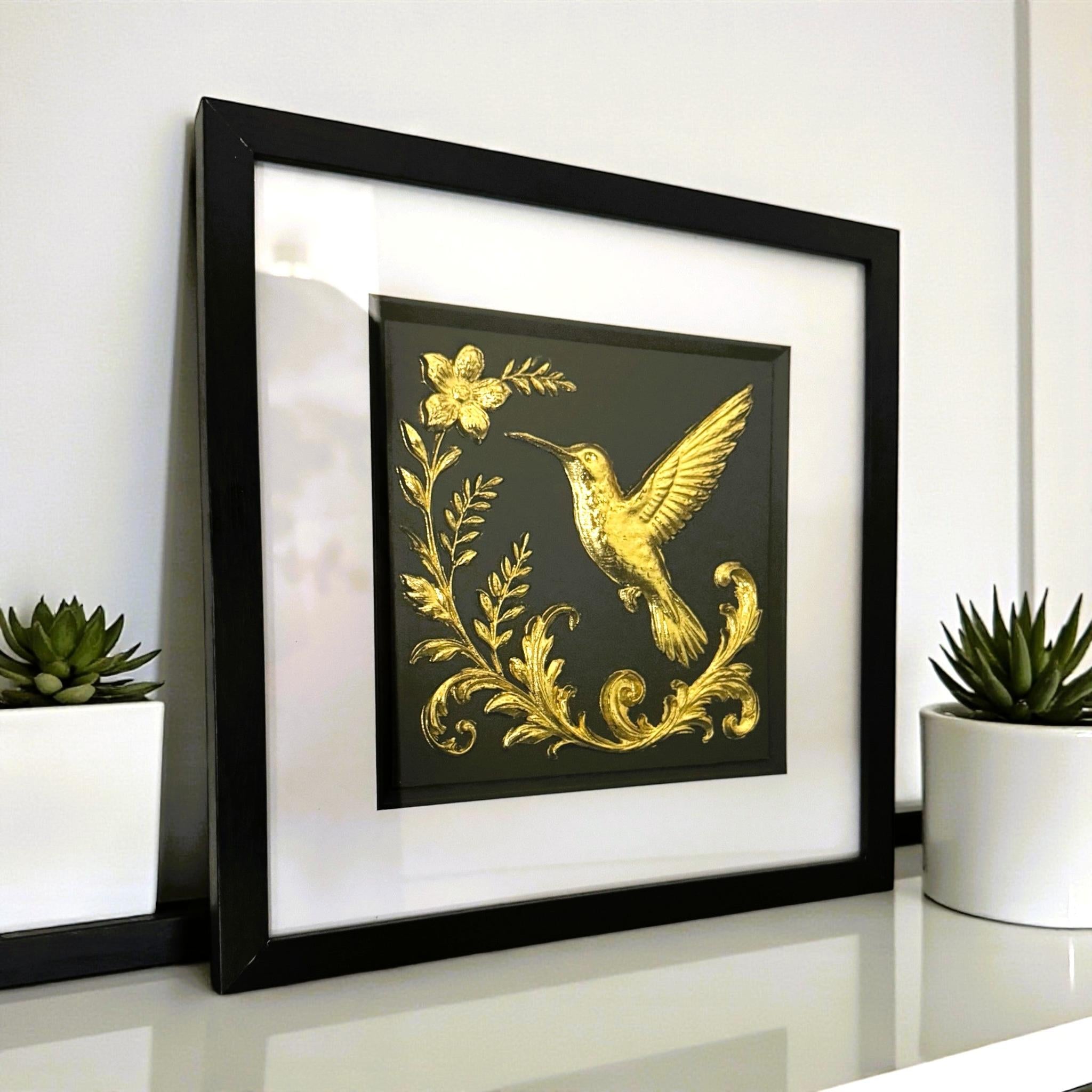 Angled wall-mounted view of gold leaf hummingbird artwork showing frame depth