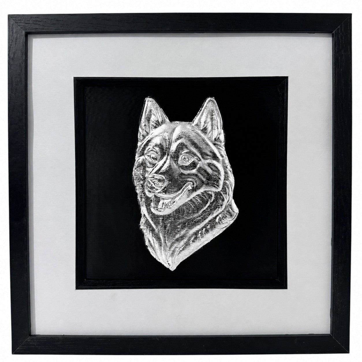 Siberian Husky framed wall art showing a sculpted dog portrait in silver leaf, set on a black background with white mount and black wooden frame
