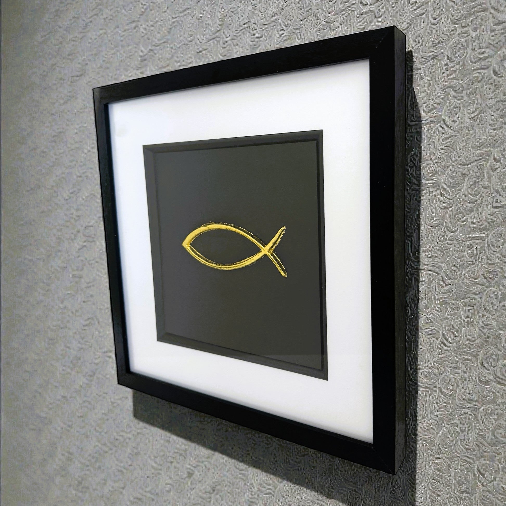 Angled view of framed Ichthys fish wall art displayed on wall