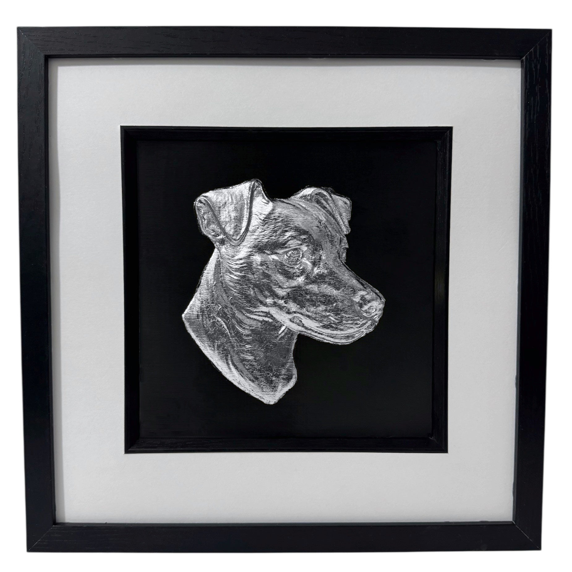 Jack Russell Terrier framed wall art showing a sculpted dog portrait in silver leaf, set on a black background with white mount and black wooden frame
