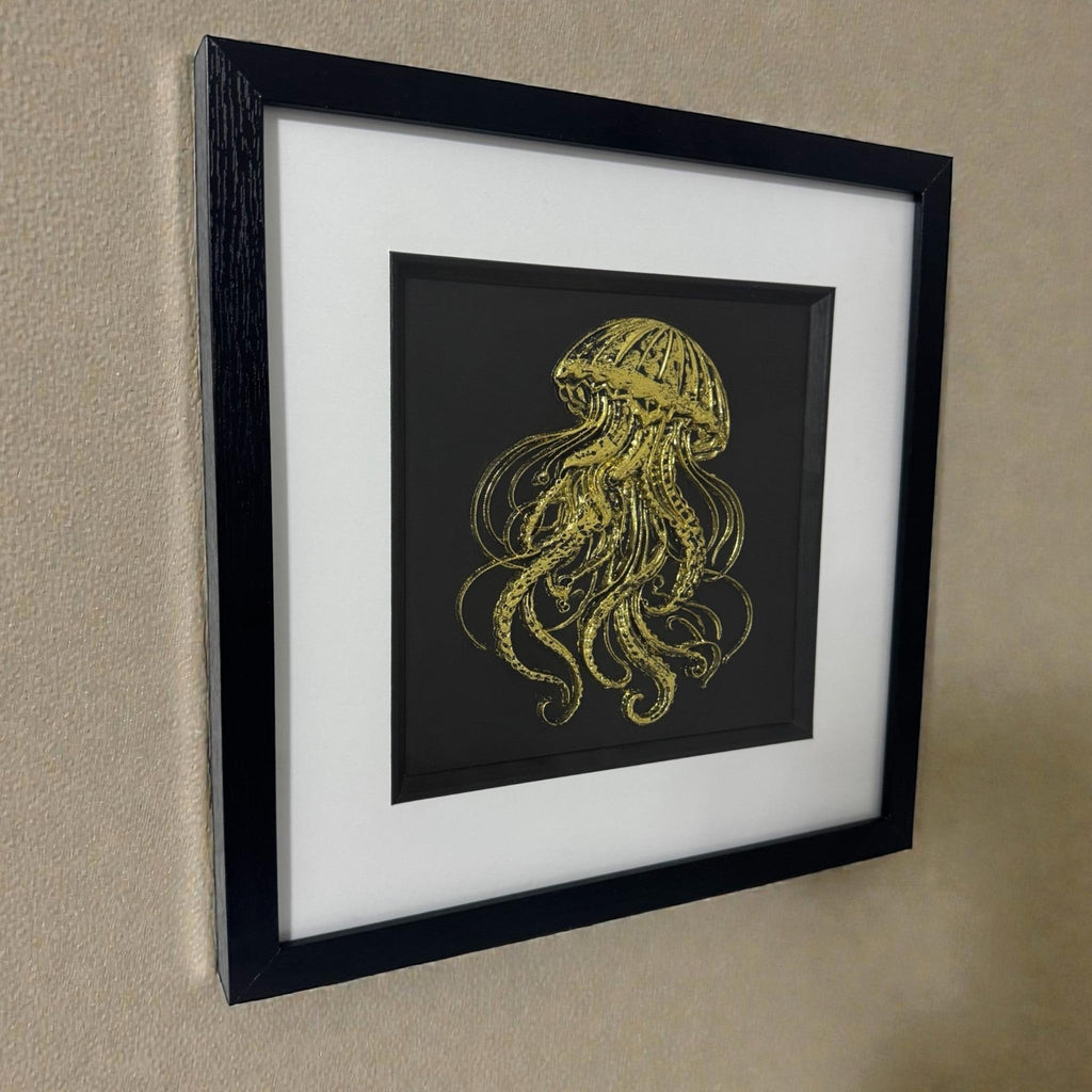 Gold leaf 3D jellyfish wall art on beige wall, framed ocean wall art with black box frame and white mount.