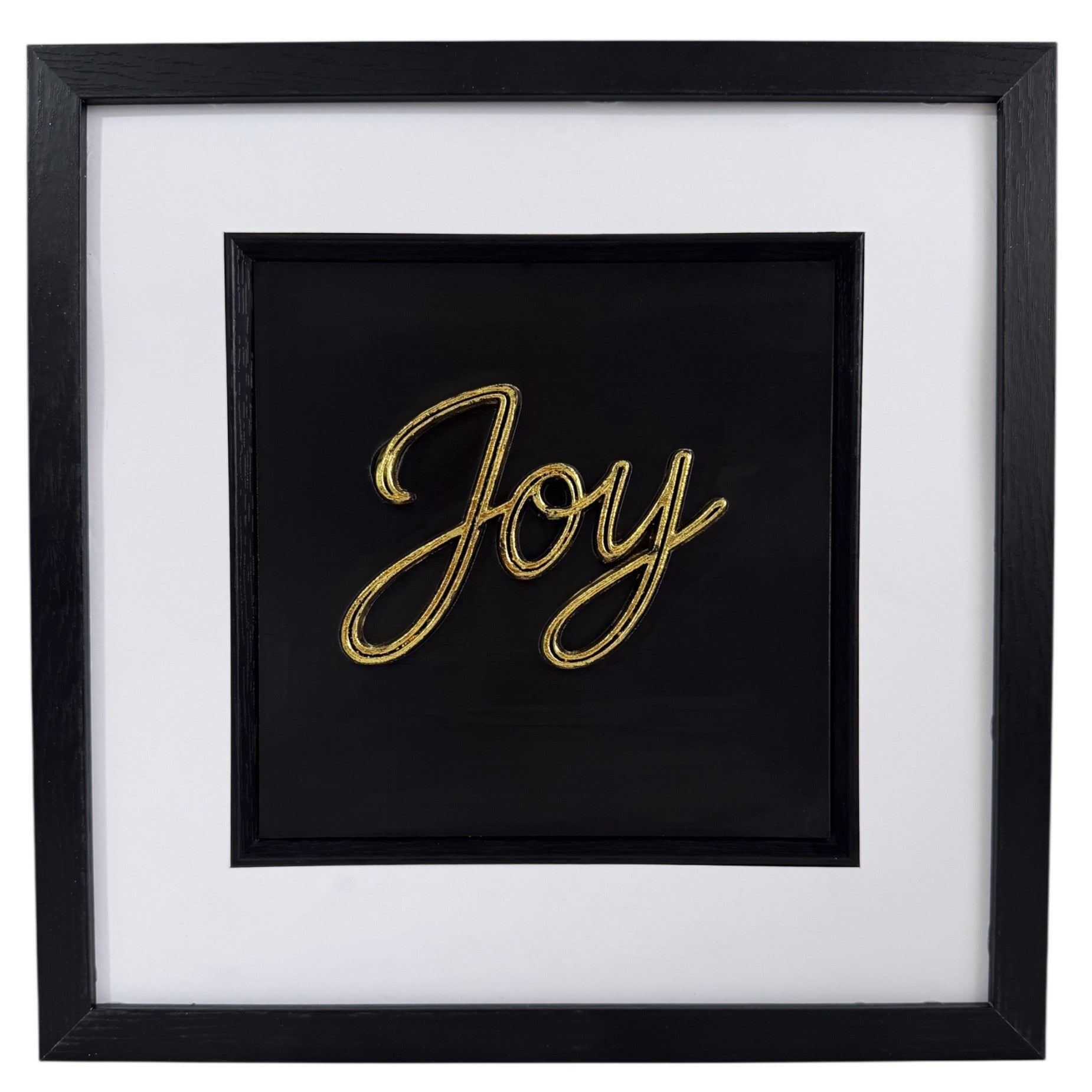 Gold framed Joy word artwork with raised script lettering, black centre panel, white mount and black frame.