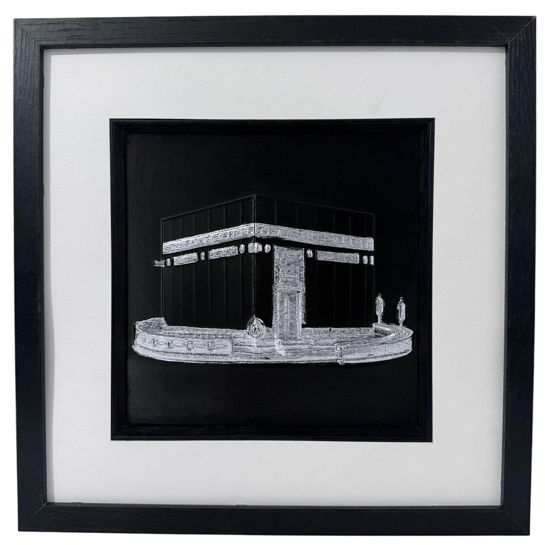 Silver Kaaba relief in a black box frame with wide white mount and black inner surround.