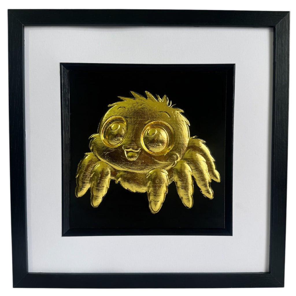Front view of Gold jumping spider wall art in a black box frame with white mount and black background