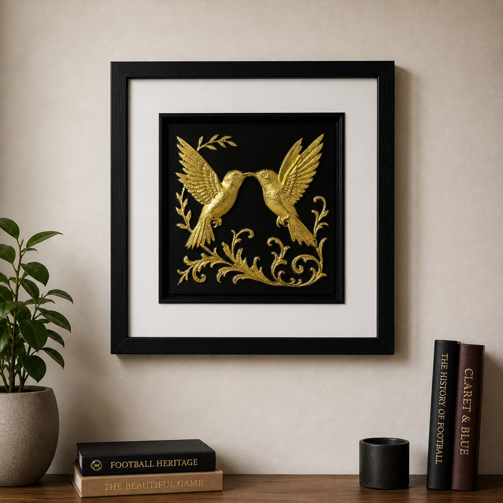 kissing hummingbird wall art gold leaf, on a neutral modern wall, with books
