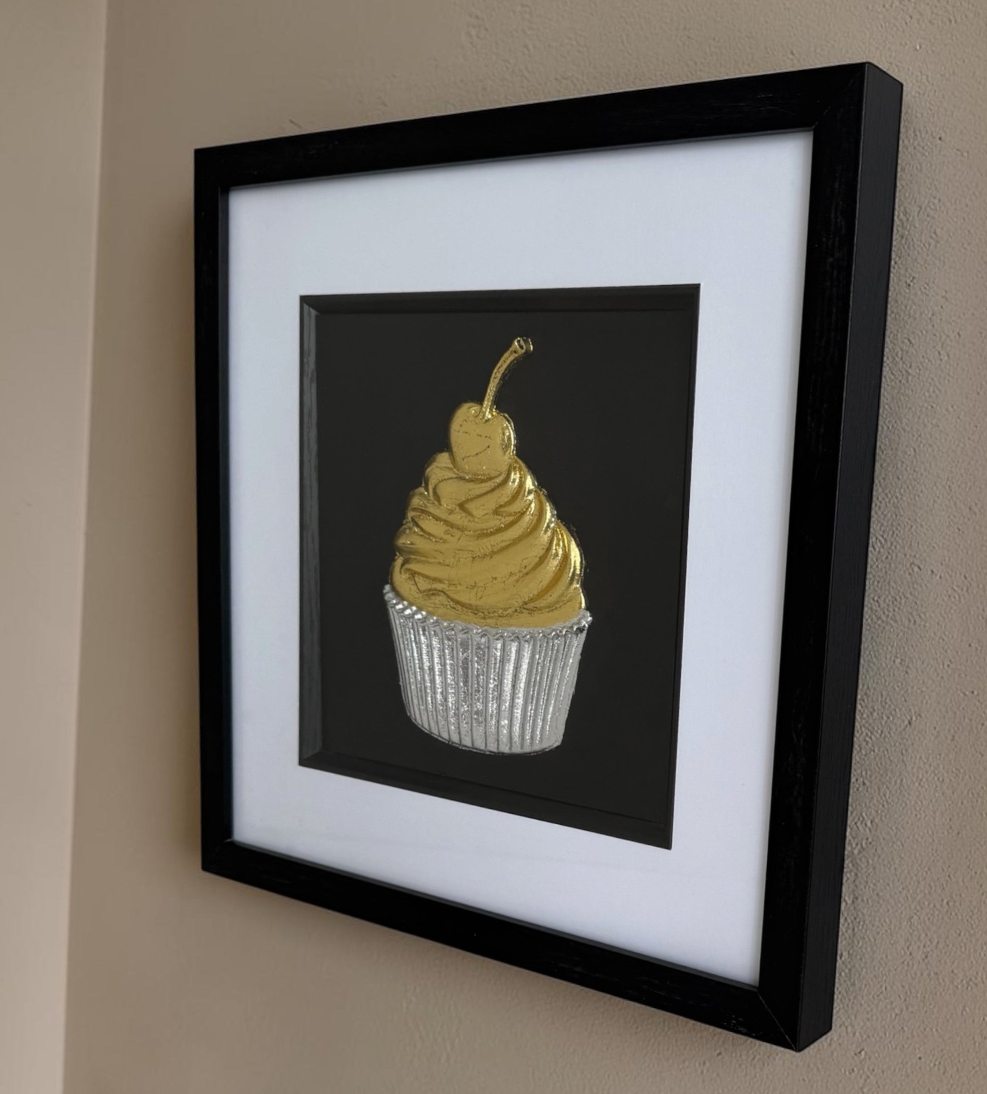Side view of cupcake kitchen artwork showing black box frame depth and white mount.