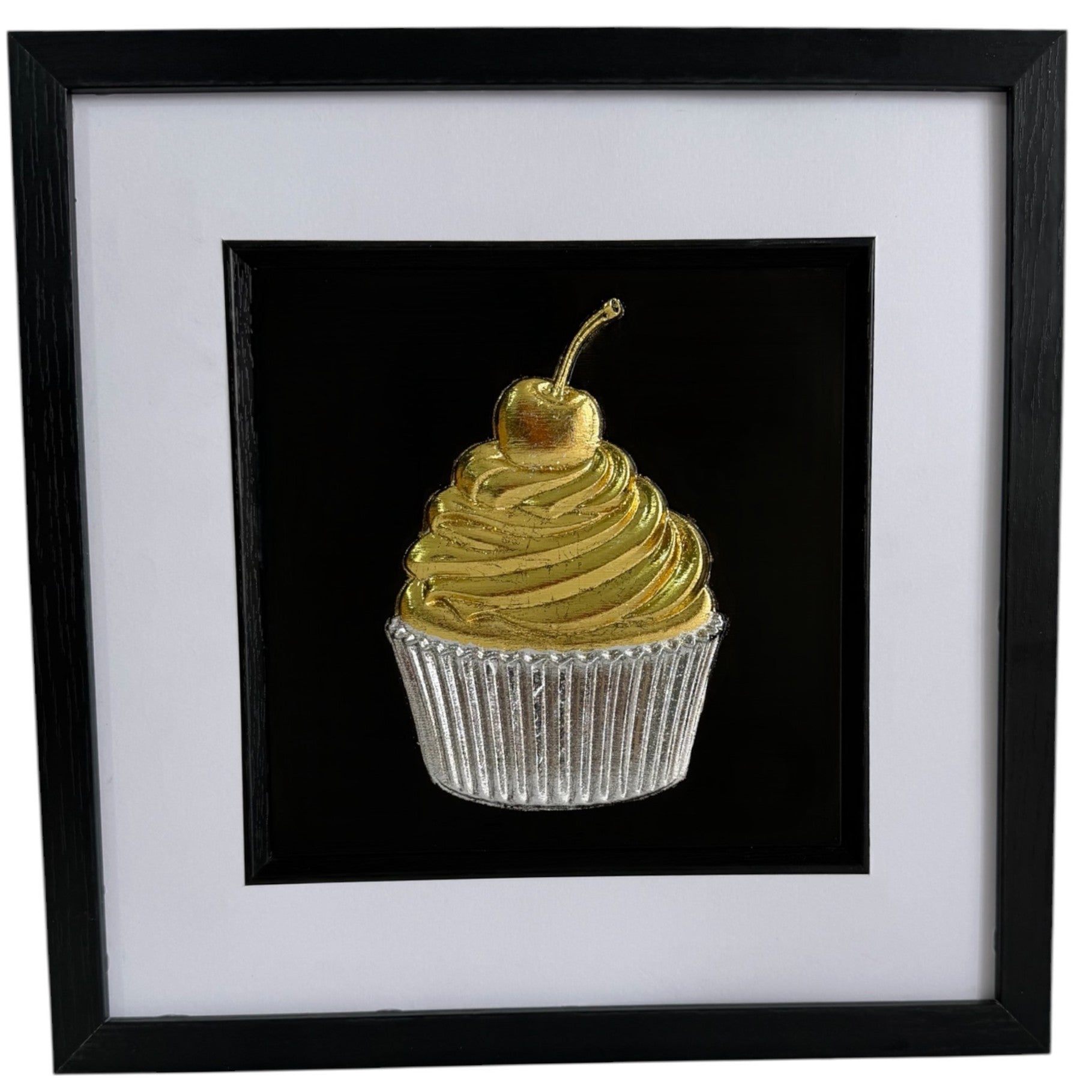 Gold and silver cupcake framed artwork with swirled icing, cherry and ribbed cupcake case.