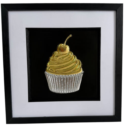 Gold and silver cupcake framed artwork with swirled icing, cherry and ribbed cupcake case.