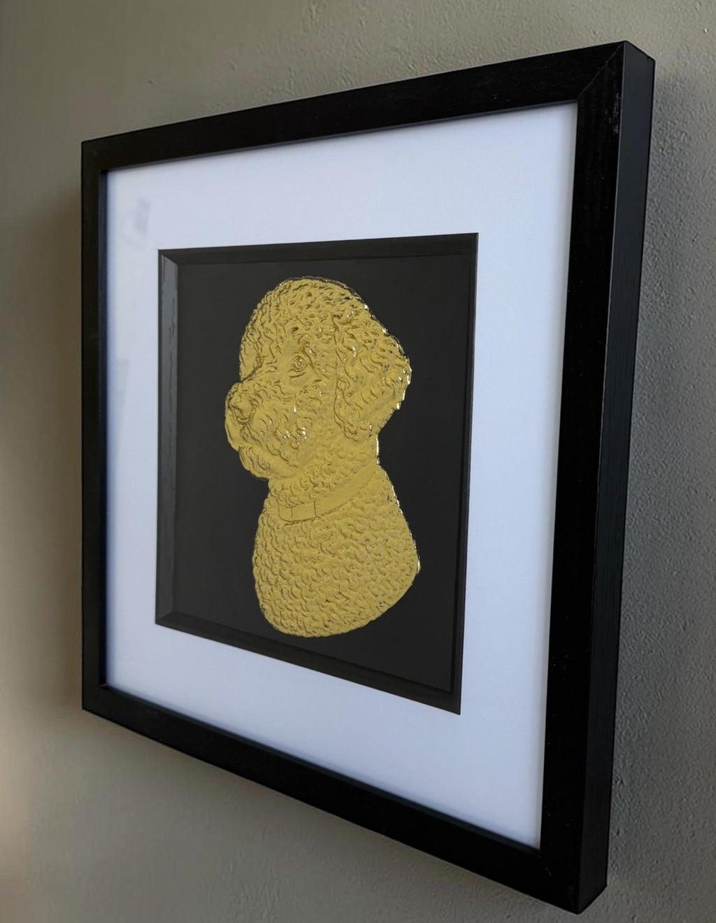 Angled wall view of a gold Lagotto Romagnolo portrait in a black box frame with glass front, white mount, and black inner surround.