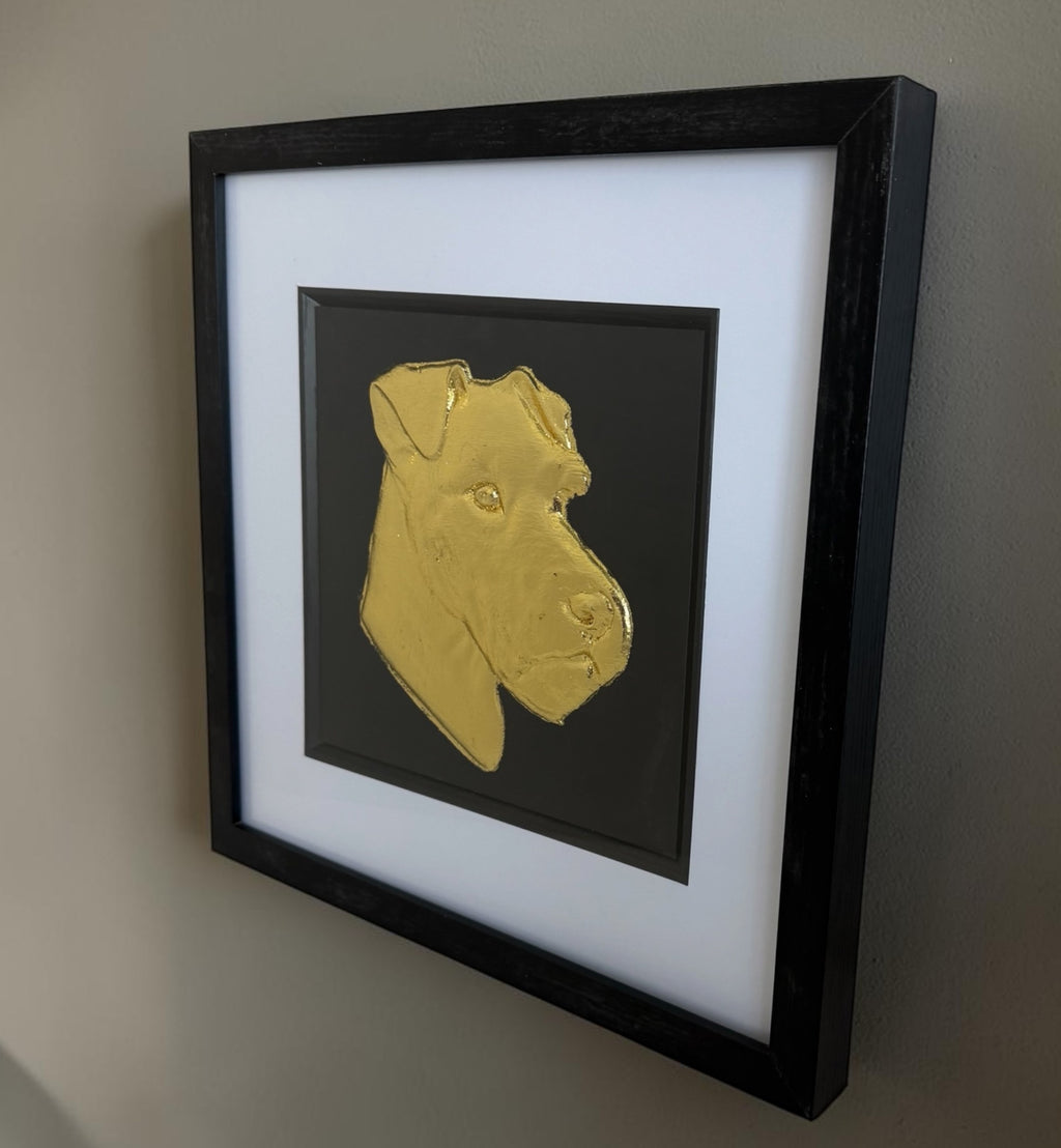 Lakeland Terrier framed wall art mounted on a wall, featuring a gold leaf dog portrait on a black background