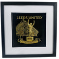 Front view of framed Leeds United stadium and Billy Bremner statue relief artwork in Gold Leaf with black box frame and white mount