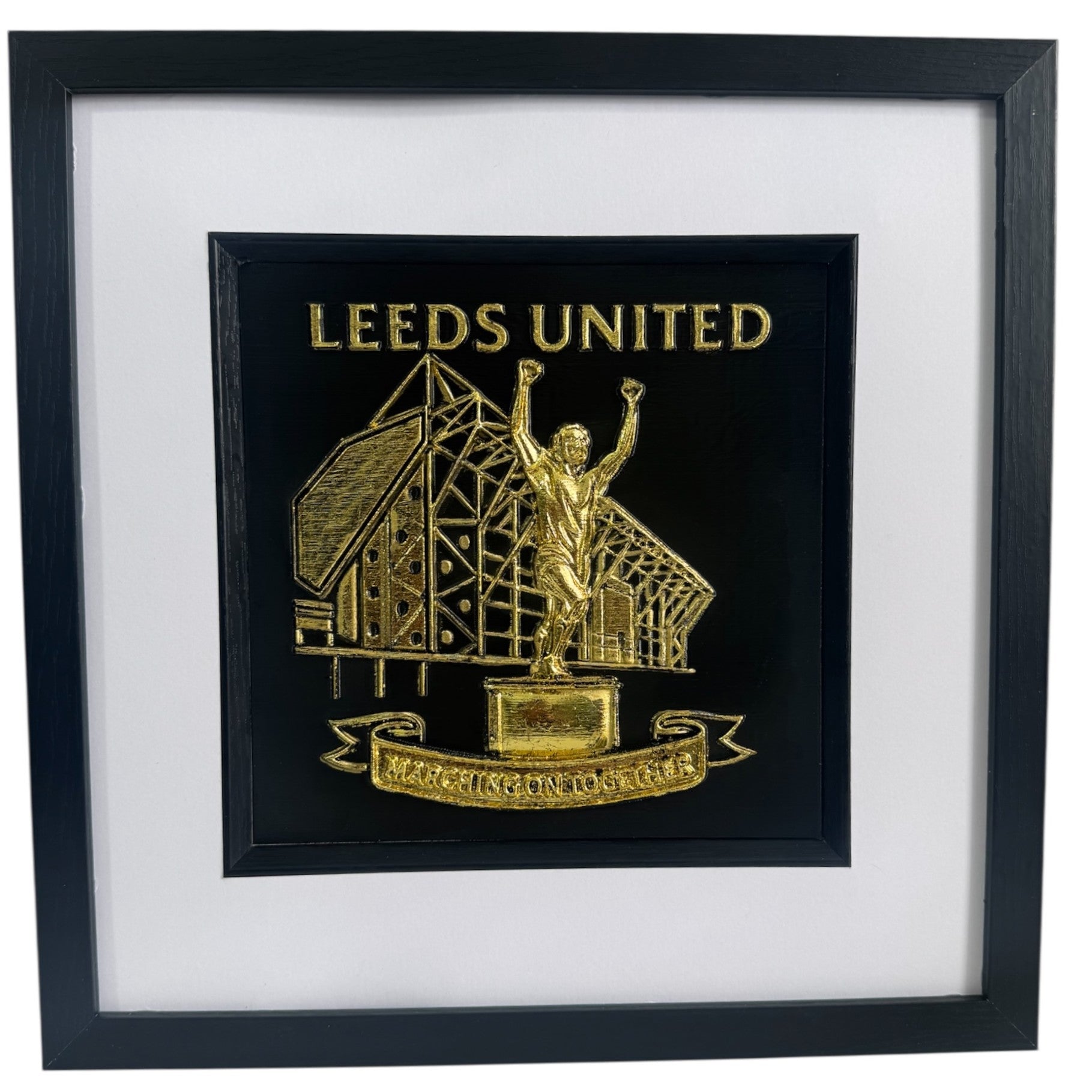 Front view of framed Leeds United stadium and Billy Bremner statue relief artwork in Gold Leaf with black box frame and white mount
