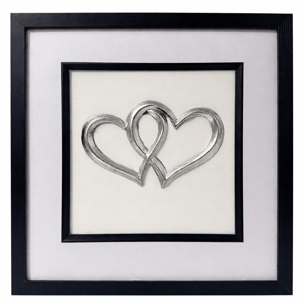 Front-facing silver leaf joined hearts wall art on a ivory background in a black frame