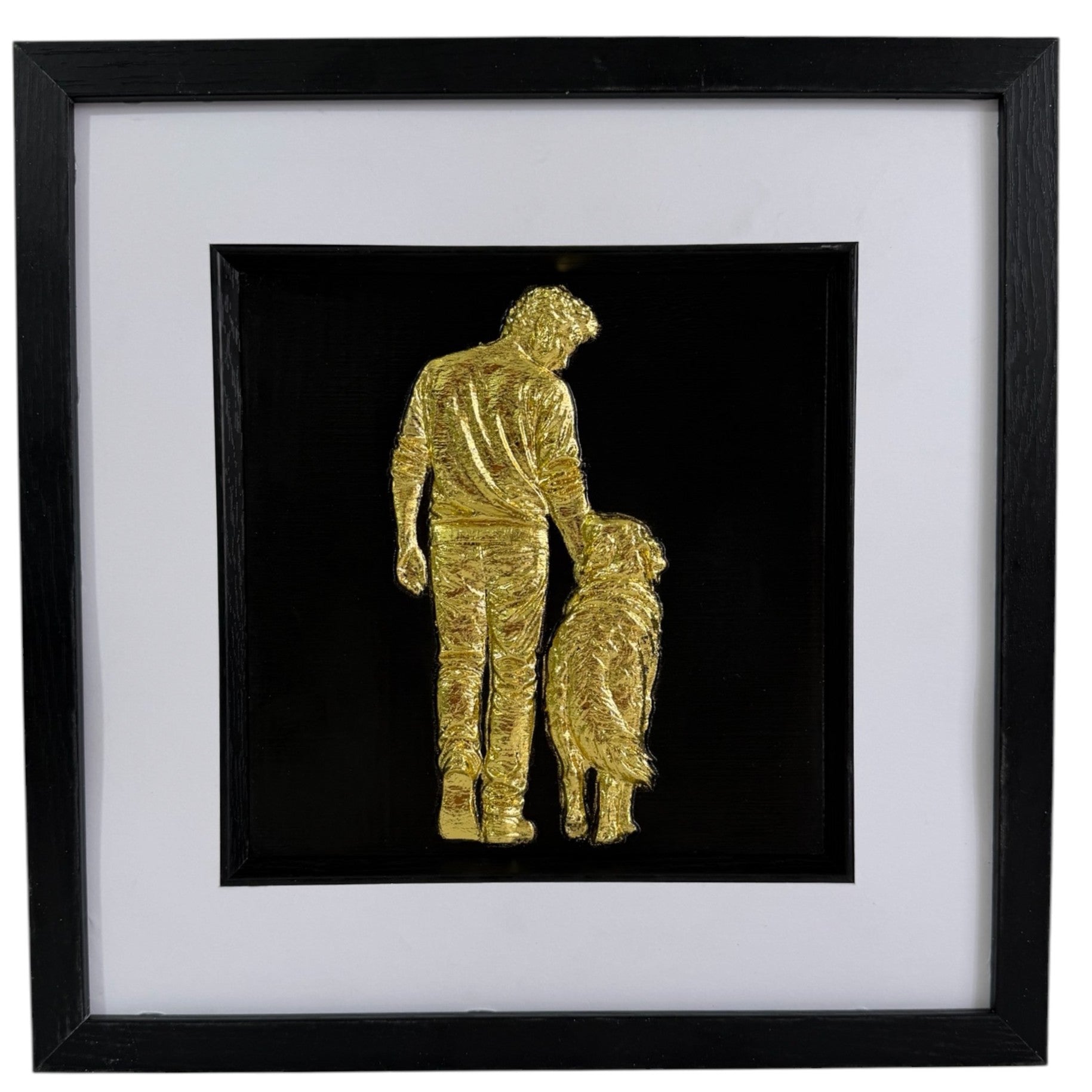 Gold finish framed 3D dog memorial gift with raised man and dog design, white mount and black frame.